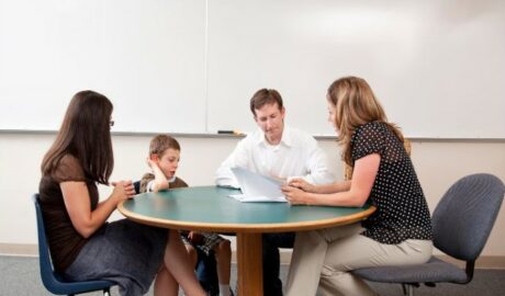 parents élève enseignante autour d'une table