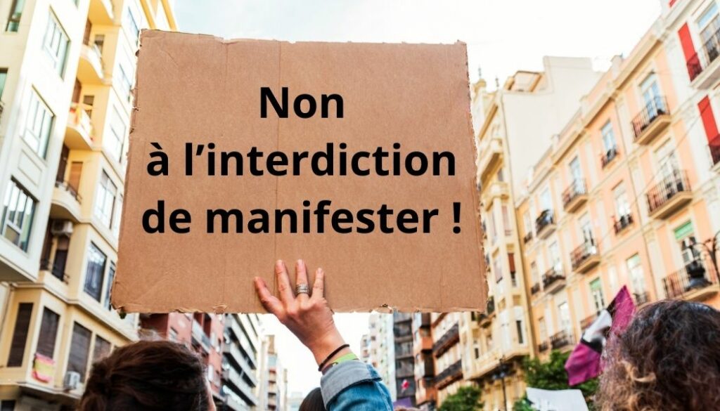 manifestation où il est écrit sur une pancarte "Non à l'interdiction de manifester !"