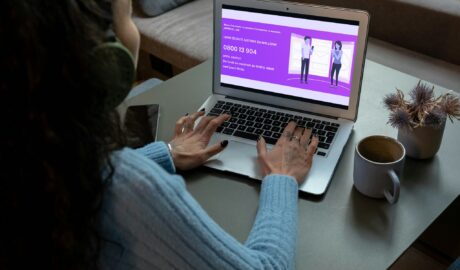 Ligne écoute autisme : une femme de dos, avec un casque sur la tête, devant un ordinateur où s'affiche le site internet de LEA